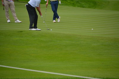 Low section of men standing of golf course