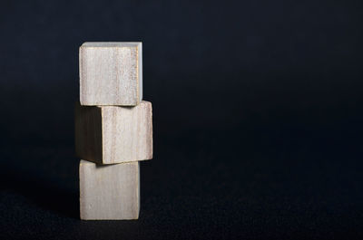 Close-up of stacked wooden blocks on black table