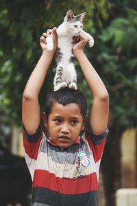 Boy holding kitten on head