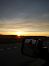 Car on road against sky during sunset