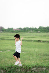 Full length of man standing on field against clear sky