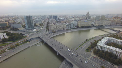 Aerial view of bridge over river against sky in city