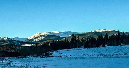 Scenic view of snowcapped mountains against clear blue sky