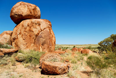 Rock formations on landscape against clear blue sky