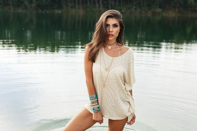 Portrait of young woman standing in lake