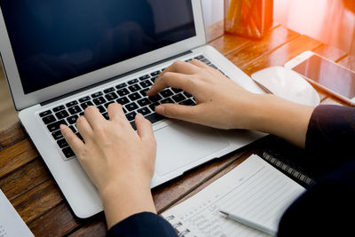 Low section of person using laptop on table