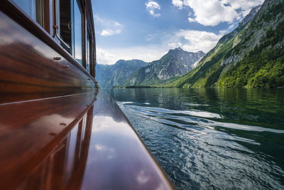 Scenic view of lake by mountains against sky