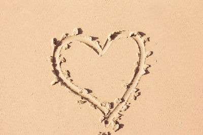 High angle view of heart shape on sand at sandy beach