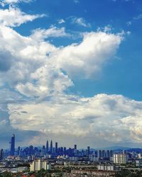 Aerial view of buildings against cloudy sky