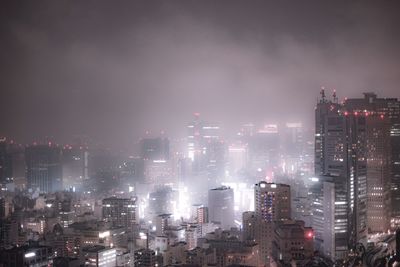 Illuminated cityscape against sky at night