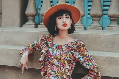 Portrait of woman standing against railing