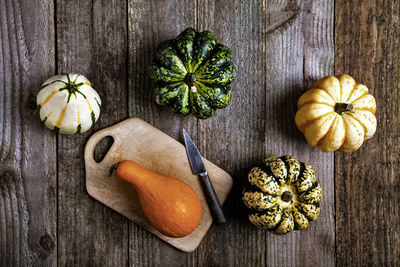 Different types of pumpkins on a rustic wooden background