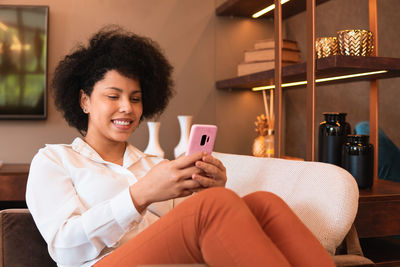 Young woman using mobile phone at home