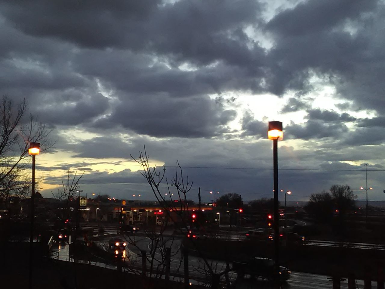 CARS ON ROAD AGAINST SKY AT SUNSET