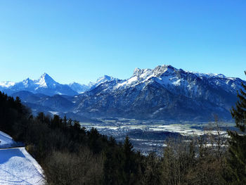 Scenic view of snowcapped mountains against clear blue sky