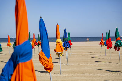 Multi colored umbrellas on beach against clear sky