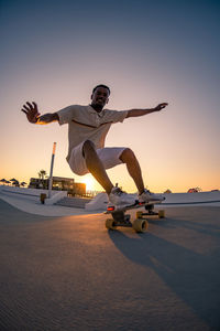 Low angle view of man exercising at sunset