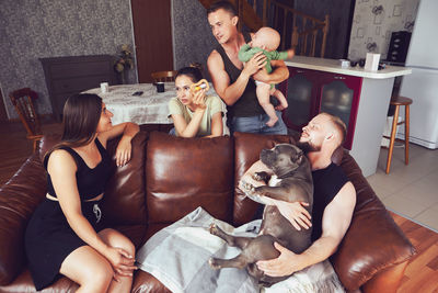 Mother and daughter sitting on sofa at home