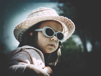 Close-up of girl wearing sunglasses and hat on sunny day