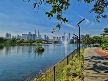 Scenic view of river by buildings against sky