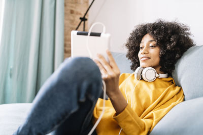 Portrait of smiling young woman sitting on sofa