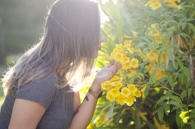 Midsection of woman against yellow flowering plants