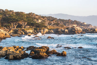 Scenic view of rocks in sea against clear sky