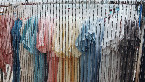 Colorful clothes hanging in store for sale