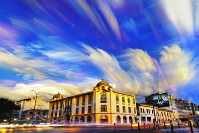 Panoramic view of city street and buildings against blue sky