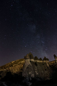 Low angle view of rock formation against sky at night