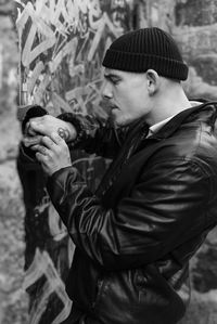 Side view of young man looking at camera