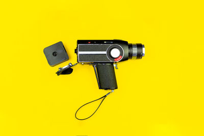 Close-up of coin-operated binoculars against yellow background