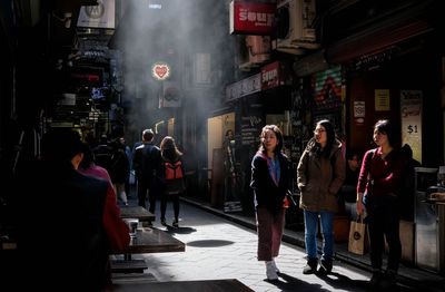 People walking on illuminated street in city