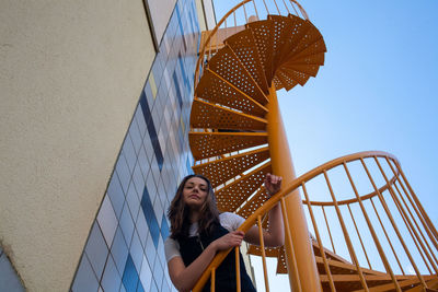 Low angle view of woman looking at staircase