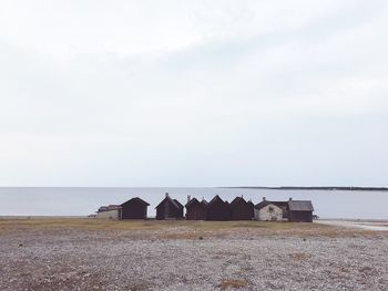 Huts on beach against clear sky