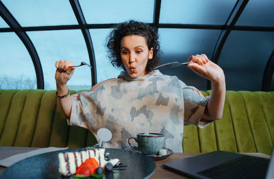 Young woman using mobile phone while sitting on seat