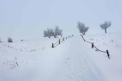 Scenic view of snow covered field against sky