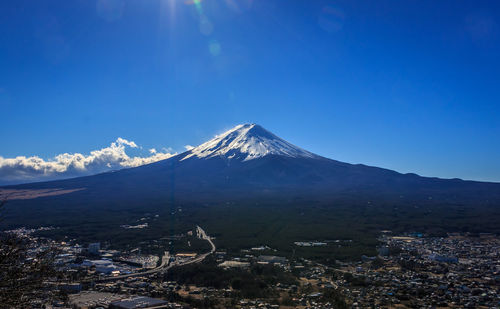 Scenic view of snowcapped mountains against blue sky