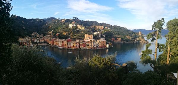 Scenic view of lake by buildings against sky