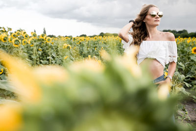 Portrait of young woman standing amidst plants