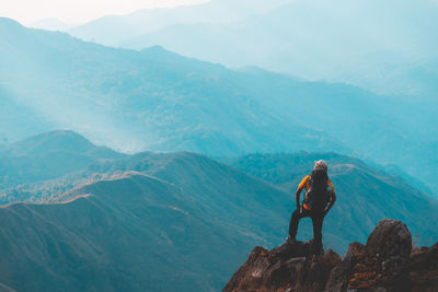 Man on rock by mountains