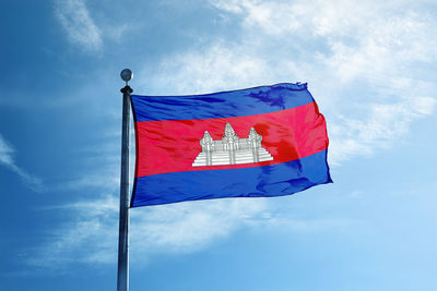 Low angle view of flag against blue sky