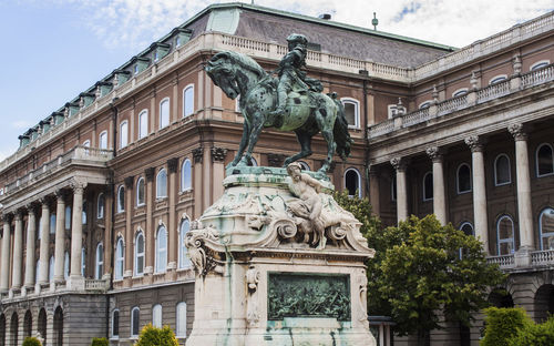 The baroque royal palace in budapest, hungary, europe. equestrian statue, columns and ornaments.