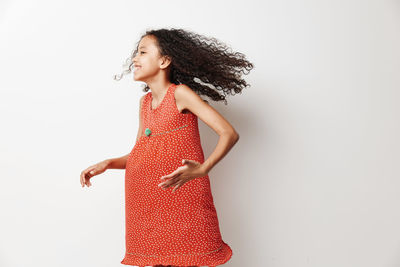 Portrait of young woman standing against white background