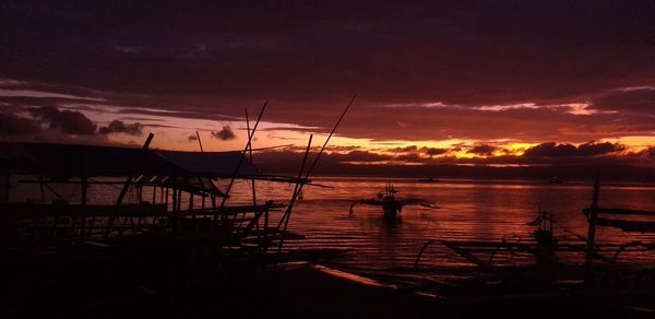 Silhouette sailboats in sea against sky during sunset