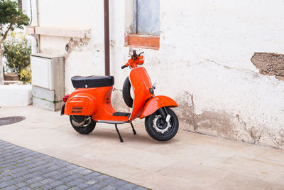 Motor scooter on street against building