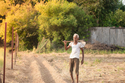 Full length of man standing on dirt road