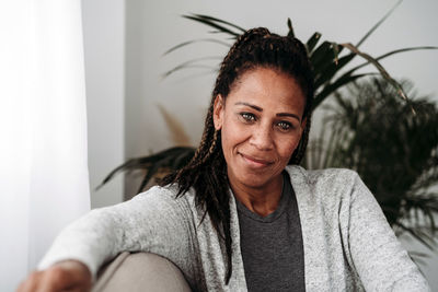 Smiling mature woman sitting in living room at home