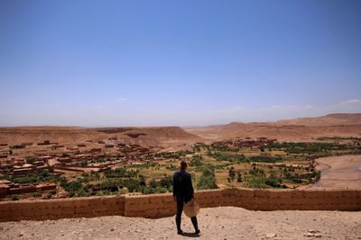 Rear view of man on desert against sky