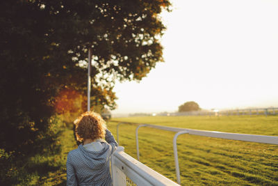 Rear view of woman standing on road